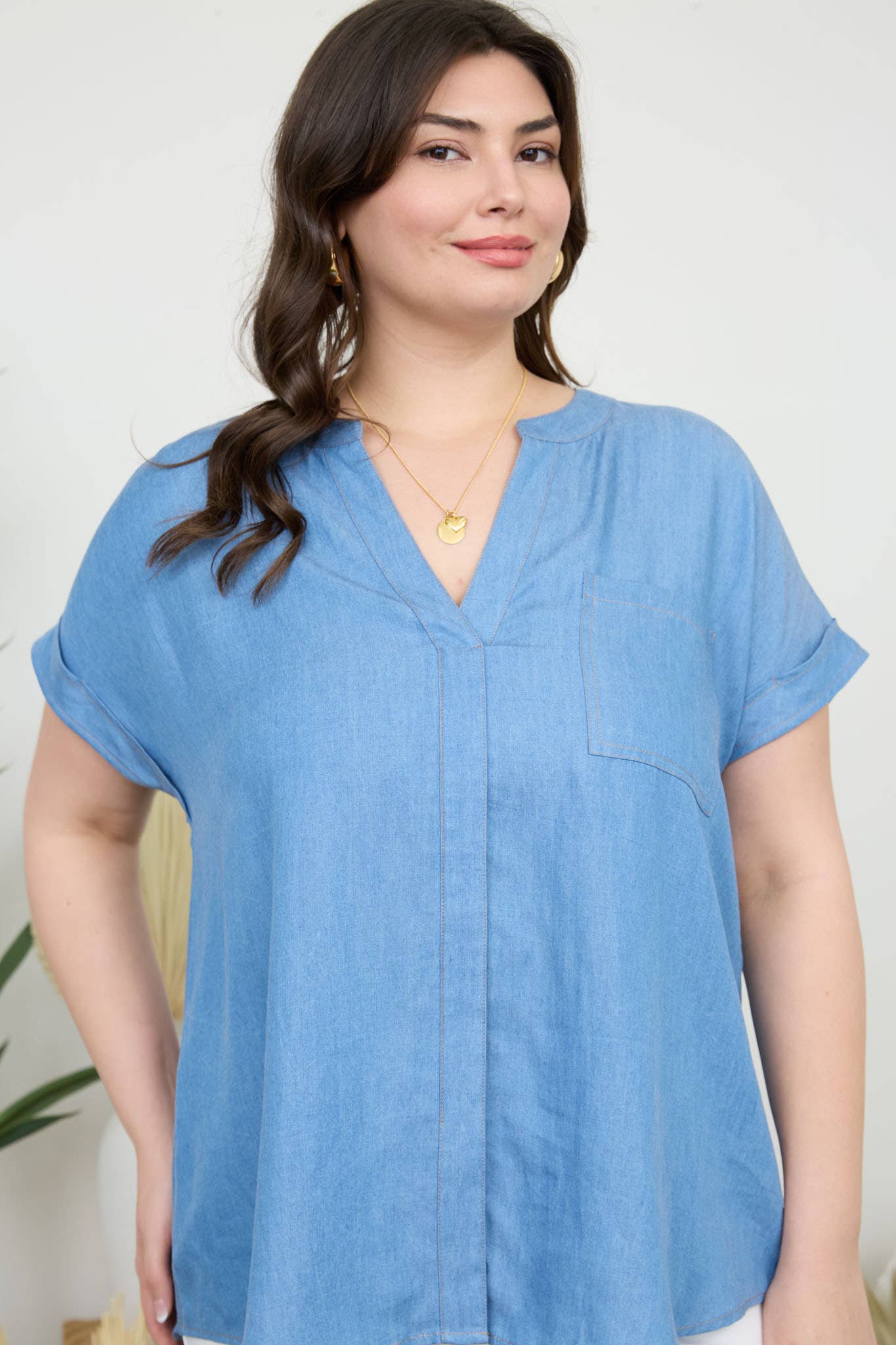Stylish PLUS BACK BUTTON CUFF SLEEVE CHAMBRAY TOP featuring a split neckline and pocket detail for a trendy look.