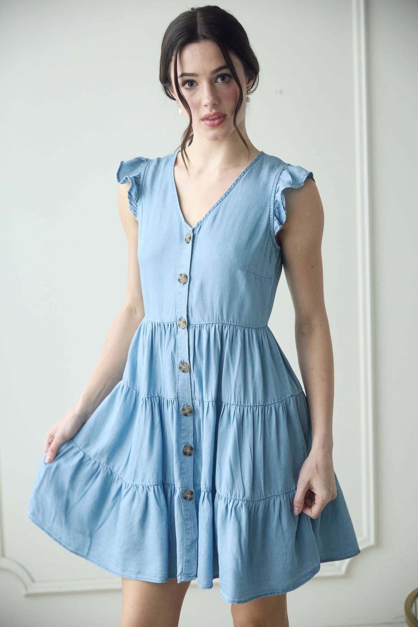 Stylish CHAMBRAY BUTTON DOWN TIERED MINI DRESS with flutter sleeves and tortoise buttons, perfect for summer outings.