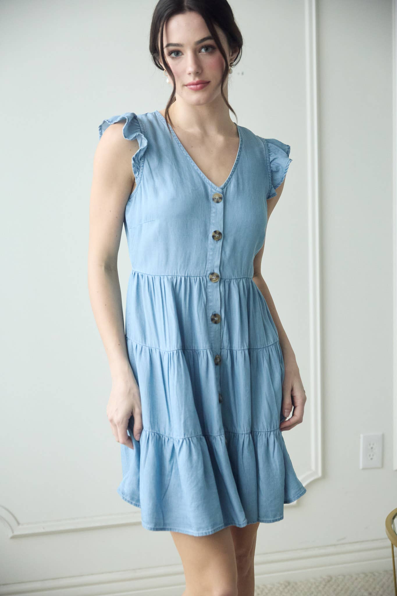 Stylish CHAMBRAY BUTTON DOWN TIERED MINI DRESS with flutter sleeves and tortoise buttons, perfect for summer outings.