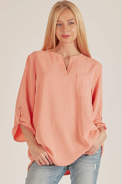 Stylish Pocket Blouse in soft coral, featuring a front pocket and loose fit, perfect for any occasion.
