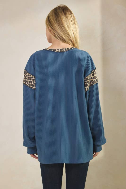 Animal contrast top: blue ribbed long-sleeve with leopard print trim on sleeves and neckline.