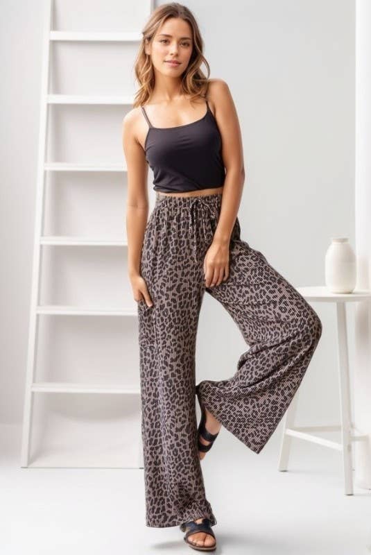 Woman wearing animal-print ribbed, relaxed-fit pants with elastic drawstring waist.