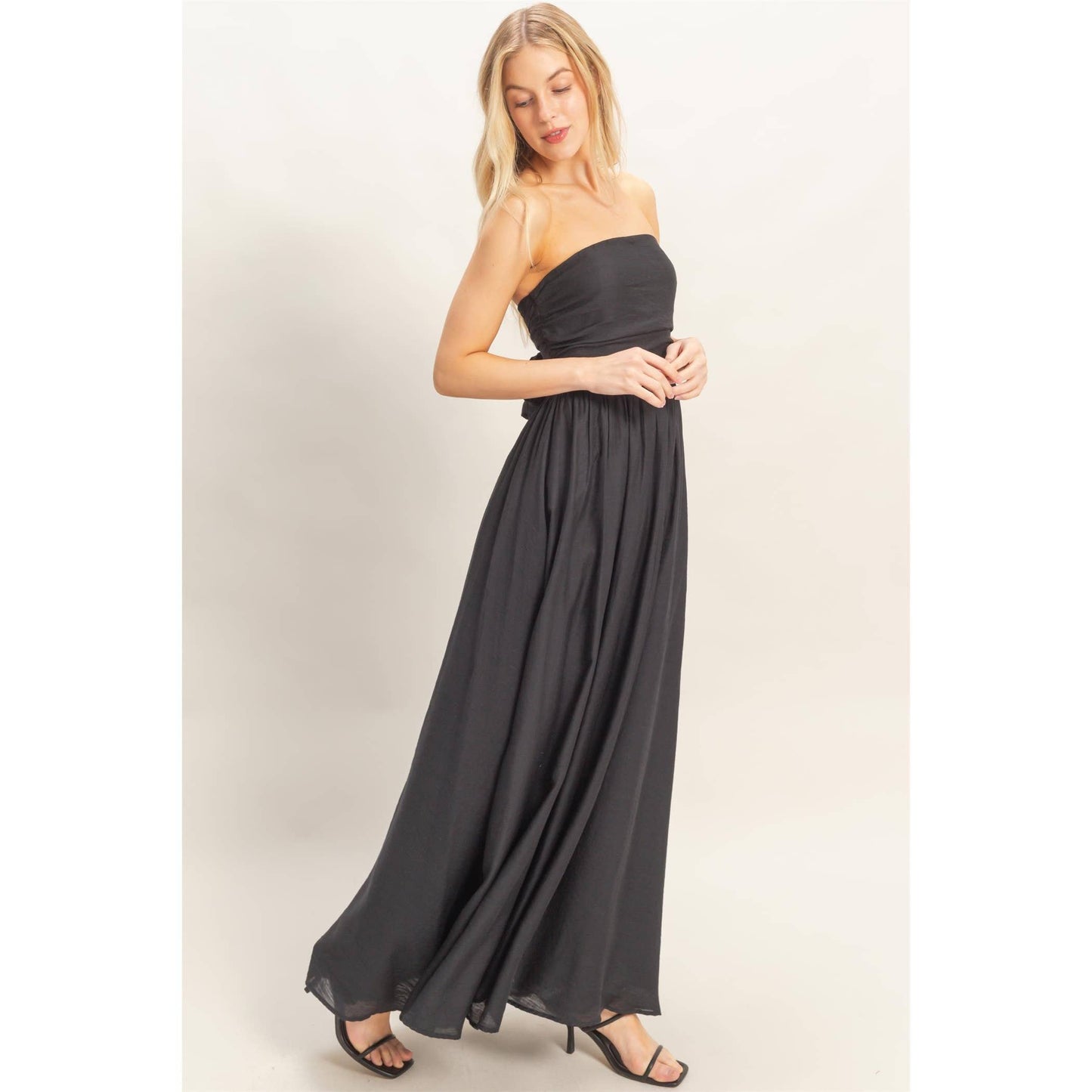 Strapless Tie-Back Smocked Dress on a model with a flowing black skirt.