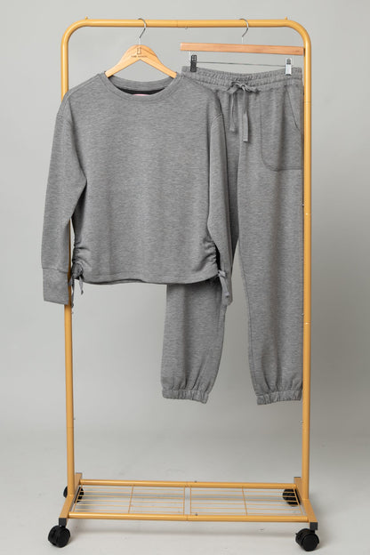 Sport Lux Set gray sweatshirt and jogger pants on a yellow rolling clothing rack.