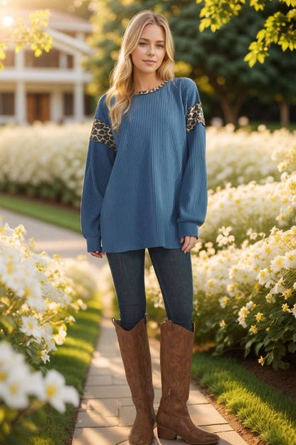 Model in Animal Contrast Top: blue rib-knit long-sleeve with leopard sleeve panels, jeans, brown knee-high boots.