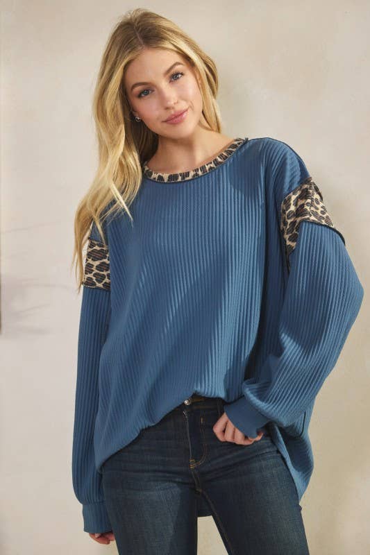 Blue ribbed long-sleeve top with leopard-print contrast trim at neckline and shoulders.