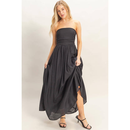 Strapless black dress with adjustable smocked back and back tie sash, flowing skirt.